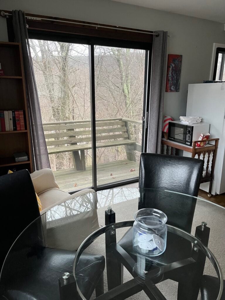 Sitting area opening onto a wood balcony and the woods